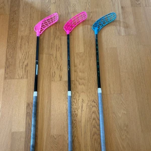  innebandyklubbor och blad - Säljer flera innebandyklubbor i bra skick samt ett stort urval av blad i olika färger. Klubborna har fräscha grepp och bladen är i gott skick, vissa oanvända. Perfekt för både träning och match. Inga synliga defekter eller större slitage.