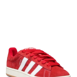 Campus 00s röda - Säljer ett par röda Adidas Campus 00s sneakers i mocka med klassiska vita ränder på sidorna och vit logga på plösen och hälen. Skorna har rund tå, platt sula och snörning. Vita snören tillkommer och orginal låda. Köpt i köpenhamn nypris 1100 kr. Lägg gärna prisförslag💕