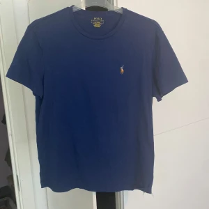 Marinblå t-shirt Polo Ralph Lauren - Marinblå t-shirt från Polo Ralph Lauren i bomull med klassisk rund hals och broderad logga på bröstet. Modellen är slim fit och har korta ärmar. Perfekt basic med snygg passform och stilren look.