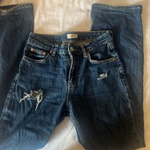 utsvängda jeans från gina! - Säljer ett par blå jeans från gina i storlek 34. Jeansen är från början helt vanlig men har själv lägst till skal håll. jeansen är utsvängde och är mid waist. 