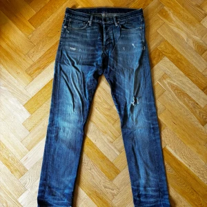 Jeans från denim&supply - Säljer ett par unika Ralph luren denim&supply jeans i blå tvätt med snygga slitningar och lätt distressed look. Klassisk femficksmodell med rak passform och normal midja. 