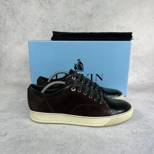 LANVIN DBB1 CAP TOE SNEAKER - – Condition: 8/10  - Size: 41/UK7  – What is included: Dustbag  – Retail price: 6000 + SEK  Please note that Lanvins fit big and our recommendation is to go one size down