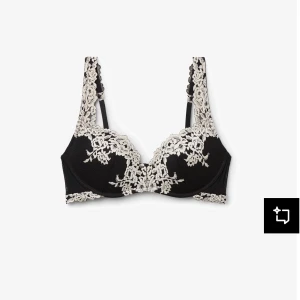 Svart spetsblus med broderade blommor - Supersnygg svart blus med kontrasterande broderade blommor i beige längs kanterna och axelbanden. Blusen har en feminin och elegant look med spetsdetaljer och v-ringning. Perfekt för dig som vill ha något extra till outfiten.