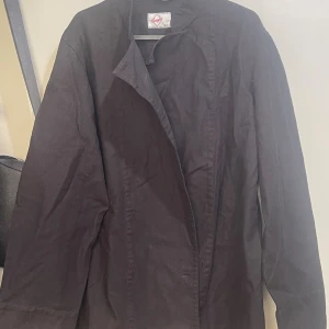 Svart kockrock  - Stilren svart kockrock, storlek C44 dam, knapprock.  Köpt från Segers. Aldrig använd. 