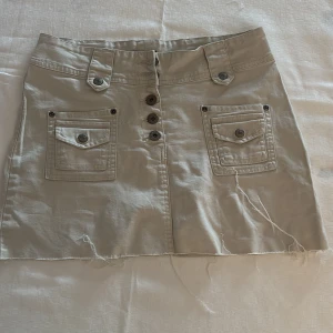 Beige jeanskjol från Lindex med knappar - Snygg beige jeanskjol knappt använd.