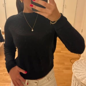 Svart stickad tröja från Zara - Mysig svart stickad tröja från Zara med rund halsringning och långa ärmar. Tröjan har en enkel och stilren design som är lätt att matcha med olika outfits. Perfekt för kyligare dagar. 
