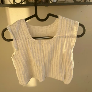 Vit ribbad virkad linnetopp -  en vit virkad linnetopp med ribbad struktur och breda axelband. Toppen är ärmlös och har en rundad halsringning. Jag har 75 B i bh storlek och den passar runt om men den blir väldigt mkt kortare då (då når den till över naveln). Virkad hemmagjord