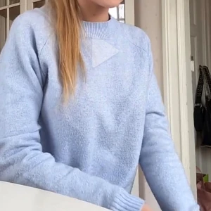 Ljusblå stickad tröja - Supermysig ljusblå stickad tröja med rund halsringning och långa ärmar. Perfekt för lager-på-lager och chill dagar. Tröjan har ribbade muddar vid ärmslut och hals, vilket ger en snygg och enkel look.