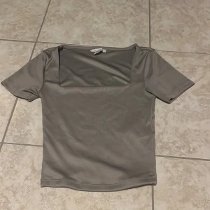 Grå topp med fyrkantig hals  - Säljer en stilren grå topp från AMISU från New Yorker i storlek XS. 