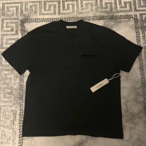 Svart Essentials Fear of God t-shirt - Svart Essentials t-shirt med tryck på baksida. Storlek M men sitter mer som en L. Oanvänd, påse och lapp medföljer. Pris kan diskuteras. 