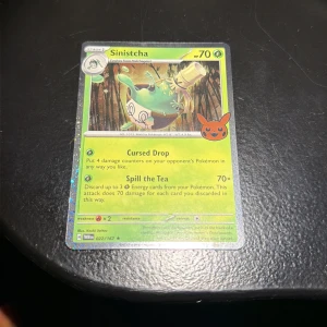 Sinistcha - Upptäck Sinistcha, en cool Pokémon-kort med unika attacker som 'Cursed Drop' och 'Spill the Tea'. Perfekt för dig som gillar samlarkort och vill boosta din lek med något annorlunda. Kortet har snygg design och passar både nya och erfarna spelare.