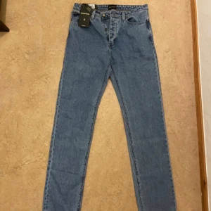 Abrand Jeans 90s Relaxed blå jeans - Snygga blå jeans från Abrand Jeans i modellen 90s Relaxed. Jeansen har en klassisk femficksdesign, knäppning med knappar och raka ben. Tillverkade i robust denim med en avslappnad passform och hög midja. Perfekta för dig som gillar en retrostil.