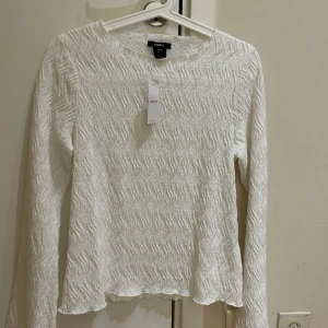  Ny kollektion Vit strukturerad långärmad topp Lindex - Ny Superfin vit långärmad topp från Lindex i storlek S. Toppen har ett vågigt, strukturerat tyg som ger en cool look och känns unik. Rak passform och mjukt material, perfekt att styla med jeans eller kjol för en fräsch vibe. Ny Lindex kollektion, jag köpte för 399 kr säljer för 280 kr 