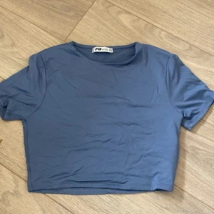 Blå croppad topp från PacSun - Säljer en enkel och stilren blå croppad topp från PacSun. Toppen har rund halsringning och korta ärmar, perfekt för att matcha med höga jeans eller shorts. Materialet är mjukt och skönt bomull. En basic topp som funkar till många olika looks.