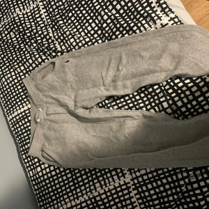 Grå mjukisbyxor från Polo Ralph Lauren - Snygga grå mjukisbyxor från Polo Ralph Lauren med klassisk logga broderad på höften. Byxorna har normal passform, dragsko i midjan och är tillverkade i mjukt bomullsmaterial. Perfekta för chill eller träning, med bekväma fickor på sidorna. Har använts en del och ett väldigt litet håll som ej är synligt men går att sy ihop på en minut. Nypris: 950kr Pris kan diskuteras