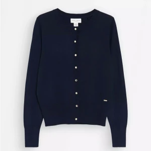 Marinblå kofta från Holly & Whyte - Snygg marinblå kofta från Holly & Whyte med rund hals och guldiga  knappar framtill. Storlek S och använd kanske 2 gånger så i nyskick! Skriv för fler frågor eller bilder🩷