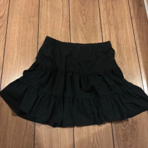 Svart volangkjol  - Supersöt svart kortkjol. 