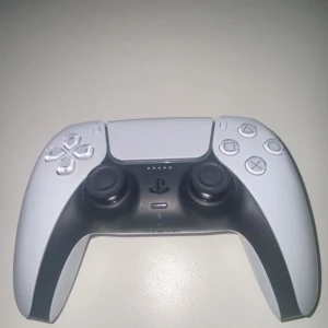 PlayStation 5 DualSense Wireless Controller - Snygg och modern DualSense trådlös handkontroll till PlayStation 5. Kontrollen är i mycket gott skick utan synligt slitage eller repor. Ergonomisk design, adaptiva triggers och haptisk feedback för en förbättrad spelupplevelse. Perfekt för både nya och erfarna spelare.