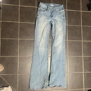 Jeans  - Populära jeans från Nelly. obs! Dem ser lite skrynkliga ut då dem är nytvättade, rättar till sig så fort man sätter på sig dem! Dem är i fint skikt endast att dem har lite slitage längst ner vid fötterna för att dem är för långa för mig men annars så ser dem oanvända ut! Dem är i storlek 34, utsvängda och lågmidjade, men fina fickor men rosa detaljer på!