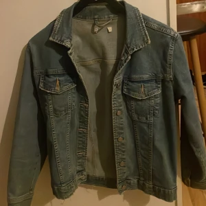 Blå jeansjacka med knappar - Snygg blå jeansjacka med klassisk krage och långa ärmar. Passar till det mesta. 