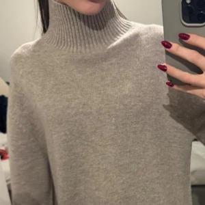 Beige polotröja i merinoull & Other Stories - Säljer en beige polotröja från & Other Stories i 100% merinoull. Tröjan har ribbad hög krage och bred ribbad kant nedtill, samt långa ärmar. Perfekt för dig som gillar stilrena och mysiga plagg med lite oversized känsla. Nypris är 1099 och kommer sälja den för detta pris för den är oanvänd och super fint skick! Kommer minst sälja den för 450