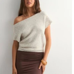 Beige offshoulder stickad topp - Säljer en beige stickad topp med offshoulder-design och korta ärmar från Nelly i storlek S. 