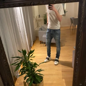Blå slim jeans med slitningar - Snygga blå slim jeans från Jack &Jones med lätt slitna detaljer och klassisk femficksdesign. Jeansen har en smal passform och normal midja, perfekta till en avslappnad stil. Tillverkade i stretchigt denim för extra komfort.