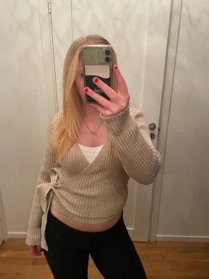 Omlottstickad tröja - Beige omlott tröja från NA-KD, inget synligt slitage! Är i storlek M men känns som S