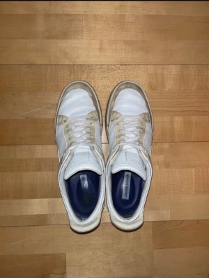 Jacob Cohën skor - Snygga vita sneakers från Jacob Cohën med detaljer i beige mocka och vit mesh. Skorna har klassisk snörning och en platt sula. Insidan är fodrad i blått tyg för extra komfort. Perfekta för en clean och stilren look.