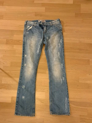 Ljusblå bootcut jeans från Levis - Säljer ett par ljusblå Levis jeans med bootcut passform. Klassisk femficksmodell med snygga sömmar och detaljer på bakfickorna. Jeansen har låg midja och är tillverkade i mjukt bomullsdenim. Perfekta för en avslappnad och trendig look.