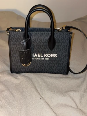 Michael Kors väska  - Michael Kors dam väska i grå/svart, använd endast 1-2 gånger. Inga märken på användning, skador eller missfärgningar. 