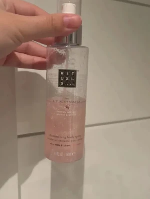 Rituals The Ritual of Sakura Body Spray - Shimmering body spray från Rituals, The Ritual of Sakura. Kommer i en genomskinlig plastflaska med spraymunstycke och rosa skimmer. Doft av ris-mjölk och körsbärsblom. Perfekt för dig som vill ha en fräsch och lyxig känsla.