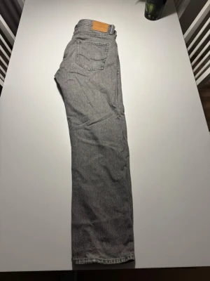 Grå jeans från Jack & Jones - Snygga grå jeans från Jack & Jones i klassisk femficksmodell. Jeansen har en rak passform och är tillverkade i mjukt bomullsmaterial med en diskret tvättad look. Perfekta för en avslappnad och stilren outfit.