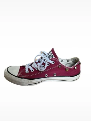 Röda Converse sneakers med nitar - Säljer ett par röda Converse sneakers med vita snören och coola metallnitar längs sopkanten. Klassisk låg modell med rund tå och vit gummisula. Perfekta för dig som vill ha en unik twist på dina sneakers.