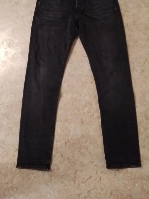 Svarta skinny jeans - Säljer ett par svarta skinny jeans med klassisk femficksdesign och smal passform. Jeansen har en enkel look utan synliga detaljer och är perfekta för dig som gillar en stilren vibe.