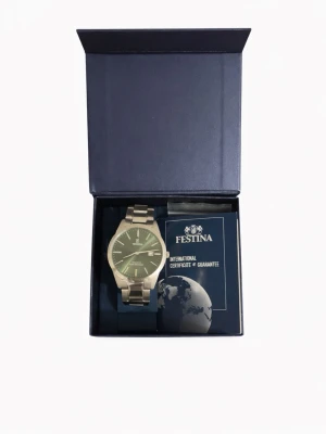 Silverfärgad klocka från Festina - Stilren klocka från Festina med silverfärgad metallarmband och rund urtavla i grönt. Klockan har minimalistisk design med tydliga markeringar och levereras i originalask med certifikat. Perfekt accessoar för dig som gillar klassisk och modern stil. Riktigt fet klocka om du frågar mig,inköpt från Ur@penn. Helt ny bara testat. Säljer pga det passar it mig längre. Skriv gärna för måt. MVH/Marko