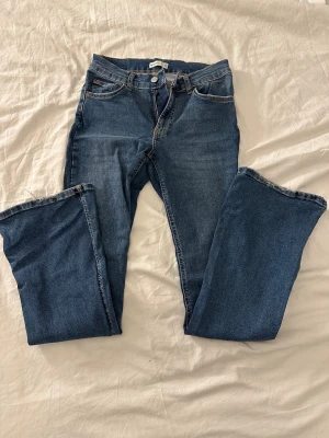Blå jeans från Gina tricot - Snygga blå jeans från Gina tricot. Lågmidjade och utsvängda. Sitter bra i storleken 