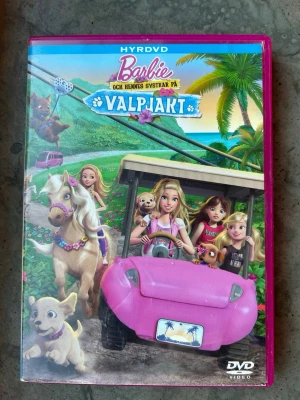Barbie och hennes systrar på valpjakt dvd - I det här sol- och badfyllda äventyret upptäcker Barbie och hennes systrar att allt blir bättre när man hjälps åt. När tjejerna och deras djur kommit fram till en paradisö för Chelseas stora dansföreställning bestämmer de sig för att göra en liten avstickare till den närbelägna festivalen för valpar.  Finns på språk: Svenska, Danska, Norska, Finska, Engelska, Arabiska  OBS!! skivorna är begagnade så det kan förekomma repor/hairlines på skivorna, men då jag kollar igenom alla filmer jag säljer