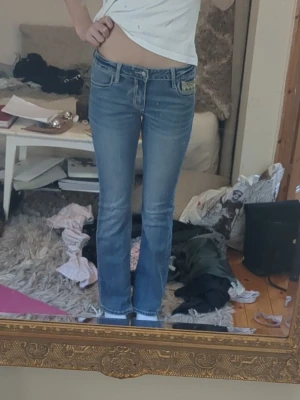 Blå bootcut jeans med mönstrade fickor - Säljer ett par blå bootcut jeans med snygga mönstrade bakfickor. Jeansen har låg midja och köpte dom på miss me. Dom passar mig bra men är lite för korta (är 168)