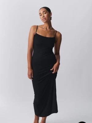 Svart långklänning med smala axelband - Säljer en svart långklänning med smala axelband och figurnära passform. Klänningen har en enkel och stilren design som framhäver siluetten. Perfekt för dig som gillar minimalistisk stil.