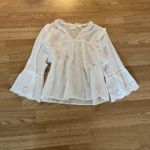 Vit blus med broderi - Supersöt vit blus från Gina Tricot med broderade ärmar. Ärmarna är typ trekvarts längd och fin passform. 