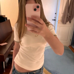 Vit t-shirt från Zara med beige detaljer - Vit t-shirt från Zara i mjuk bomull med korta ärmar och beige ribbade muddar vid ärmslut. Bra skick då den är ny med pris lap på, storlek S. Köpte för 140kr