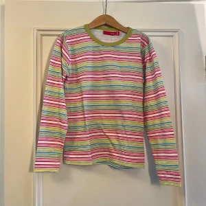 Randig långärmad tröja från Exit - Säljer en färgglad långärmad tröja från Exit med smala ränder i rosa, grön, blå, gul och vit. 