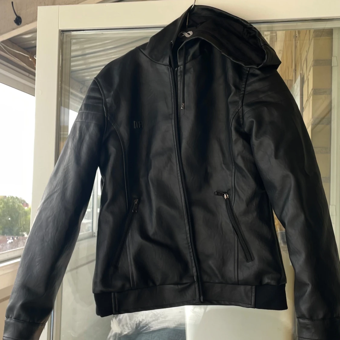 Svart skinnjacka med huva från H&M