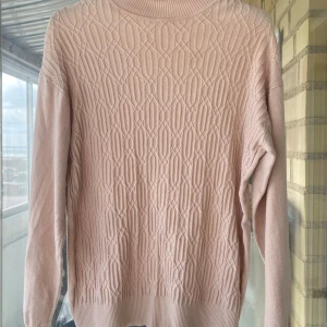 Beige polo tröja  - Säljer en polotröja med snyggt strukturmönster framtill. Tröjan har ribbad polokrage, långa ärmar och ribbade muddar. 