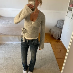 Grå omlottkofta från Gina Tricot - Supermysig grå omlottkofta från Gina Tricot i stickad kvalitet. Koftan har långa ärmar, v-ringning och knyt i sidan för en snygg passform. Knappt använd. Nypris: 400kr. Storlek: xs. Skriv privat om frågor 💕
