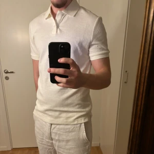 Vit pikétröja i bomull - Säljer min vita piketröja i bomull som har ett skönt material och sitter avslappnat