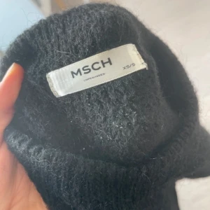Svart stickad tröja från MSCH - Mysig svart stickad tröja från MSCH Copenhagen. Tröjan är perfekt nu när kyliga dagar närmar sig och är enkel att matcha med allt. Materialet är fluffigt och ger en skön känsla. Använd något enstaka tillfälle, säljes bara för att den inte riktigt är min stil. 