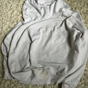 Vit hoodie med dragkedja och huva - Vit hoodie med dragkedja och huva, perfekt för chill dagar. Tröjan har långa ärmar, ribbade muddar och fickor framtill. Tillverkad i mjuk bomullsmix som känns skön mot huden. Enkel och clean stil som passar till det mesta.