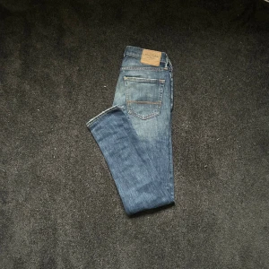 Blå slim jeans Abercrombie & Fitch - Snygga blå slim jeans från Abercrombie & Fitch med slitningar på låret och vid fickan.